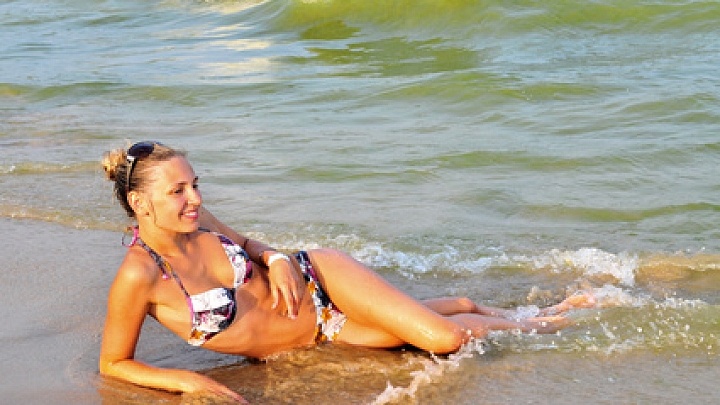 Frau liegt am Strand